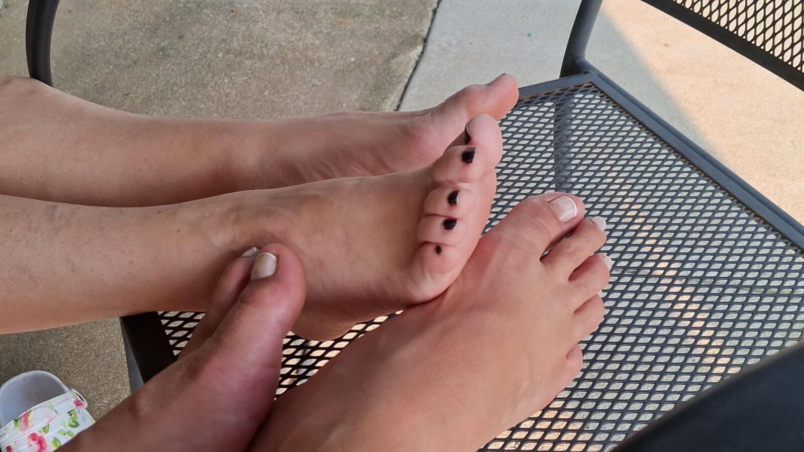 Jugando a pie al sol con nuestros pies y dedos de los pies de pedicura