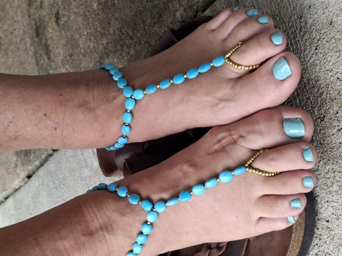 Pies lindos y dedos pintados en sandalias descalzos