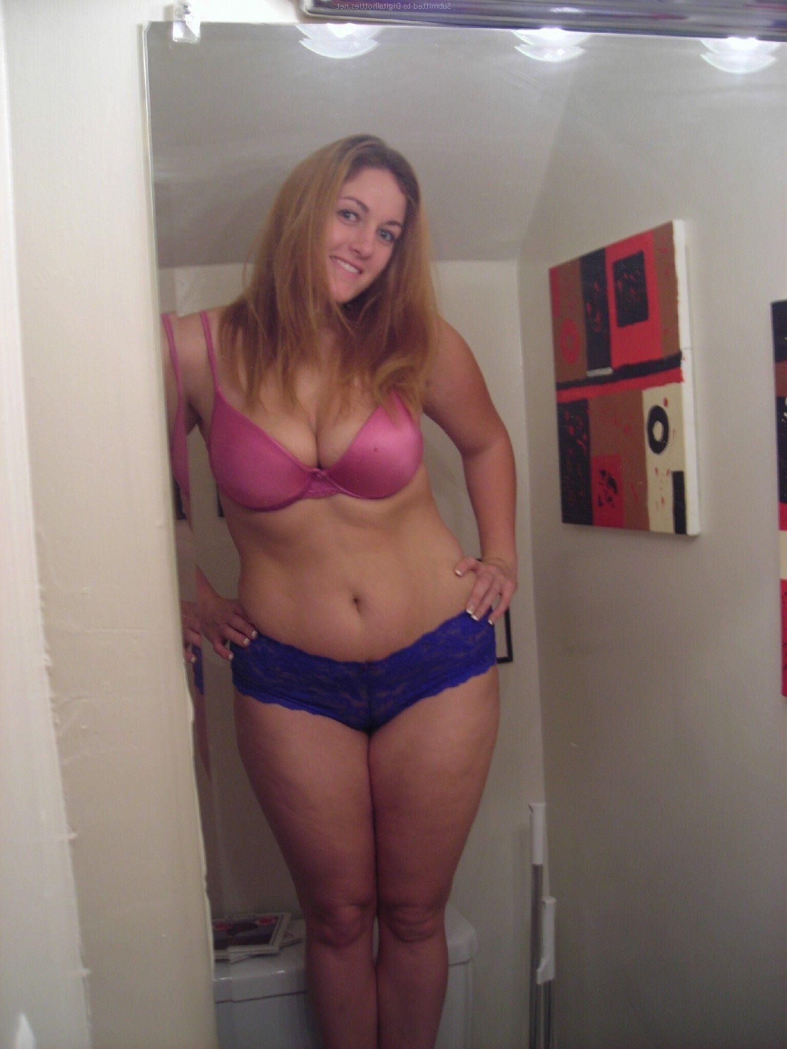 Jeune femme potelée prenant des photos coquines à la maison
